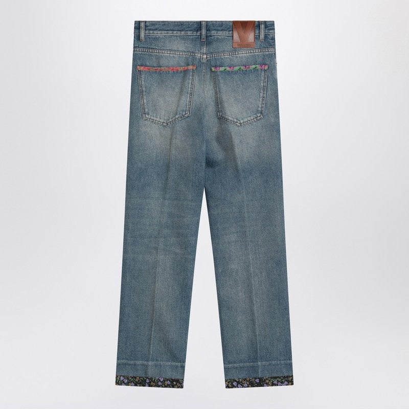 Washed blue jeans with floral fabric trims